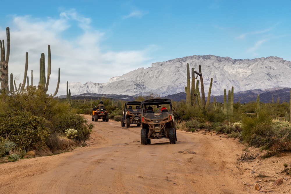 3 jeeps or 4-wheelers driving through the desert